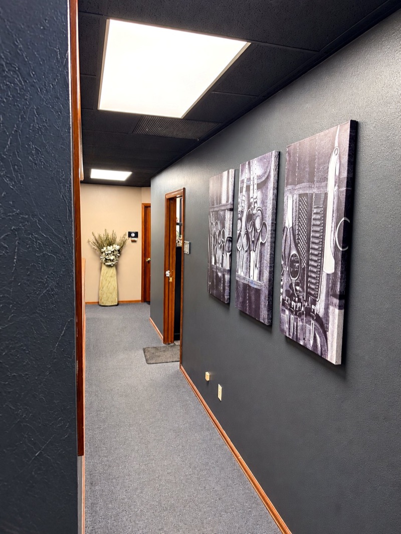 Hallway of private salon suites at Springs Spa & Salon, with framed barber-tool art on the wall