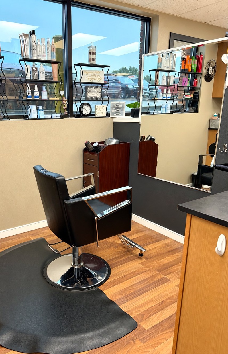 Salon booth by a large window with retail shelves at Springs Spa & Salon in Colorado Springs